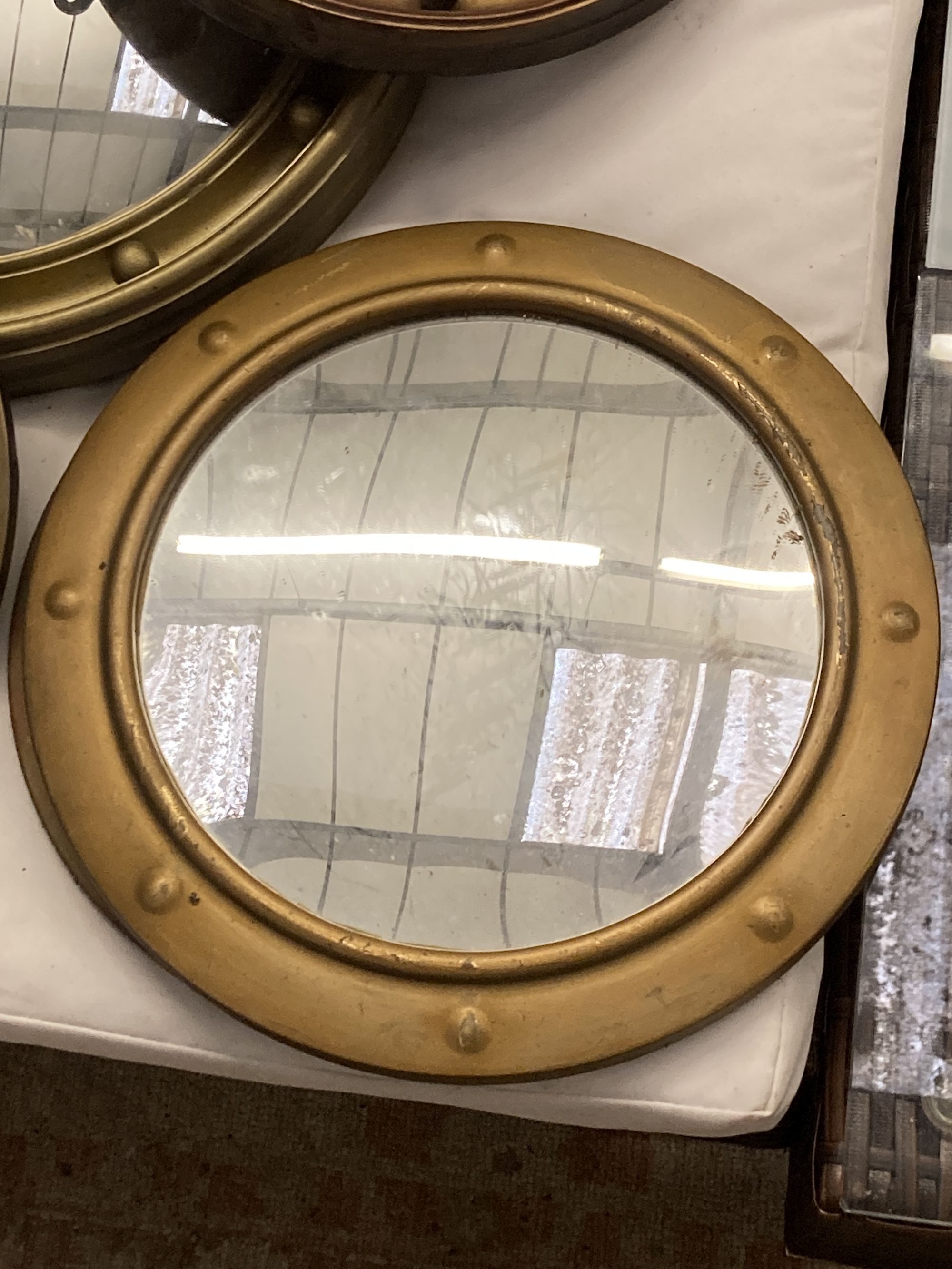 Six circular gilt and brass framed convex wall mirrors, largest 39cm diameter
